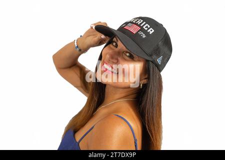Eine junge Frau, die selbstbewusst an einer weißen Wand steht Stockfoto