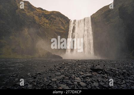 Eine atemberaubende Landschaft mit einem Wasserfall, der einen felsigen Hügel in einem üppigen Tal hinunterstürzt Stockfoto