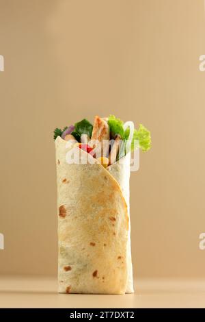 Döner, Pita, Gyros, Shaurma. Wrap-Sandwich gefüllt mit gegrilltem Huhn, Tomaten, Zwiebeln, Mais und frischem Gemüse, Street Food. Zum Mitnehmen Stockfoto