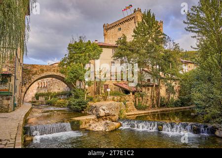 Die Stadt Potes mit dem Fluss Deva in seinem Weg und Torre del Infantado im Hintergrund. In der Region Liebana, Kantabrien, Spanien. Stockfoto