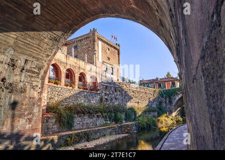 Die Stadt Potes mit dem Fluss Deva in seinem Weg und Torre del Infantado im Hintergrund. In der Region Liebana, Kantabrien, Spanien. Stockfoto