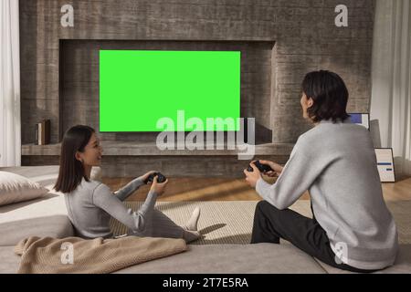 Die Menschen schauen und genießen neben dem Fernseher, Monitor mit grünem Bildschirm Stockfoto