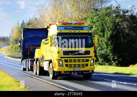 Gelbes Volvo FH Hochleistungs-Bergungsfahrzeug von Hinaus Raasepori, das im Herbst einen Sattelschlepper entlang der Autobahn zieht. Raasepori, Finnland. Oktober 2023. Stockfoto