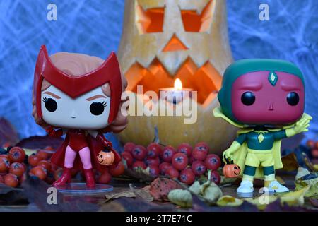 Funko Pop Actionfiguren der Marvel Superhelden Avengers Scarlet Witch Wanda und Vision in Halloween Kostümen. Jack o Laterne, Spinnennetz, Herbstblätter. Stockfoto