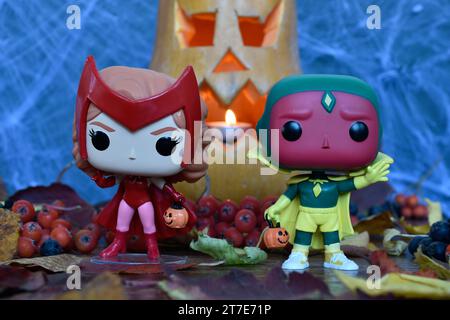 Funko Pop Actionfiguren der Marvel Superhelden Avengers Scarlet Witch Wanda und Vision in Halloween Kostümen. Jack o Laterne, Spinnennetz, Herbstblätter. Stockfoto