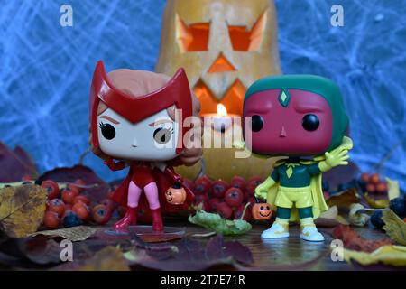 Funko Pop Actionfiguren der Marvel Superhelden Avengers Scarlet Witch Wanda und Vision in Halloween Kostümen. Jack o Laterne, Spinnennetz, Herbstblätter. Stockfoto