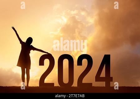 Silhouetten glücklicher Frauen und Beginn des neuen Jahres 2024. Stockfoto