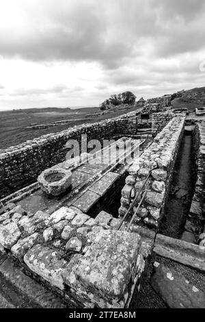 Schwarz-weiß-Blick auf die öffentlichen Latrinen des Housesteads-Forts, einer der alten römischen Forts entlang der Hadriansmauer Stockfoto