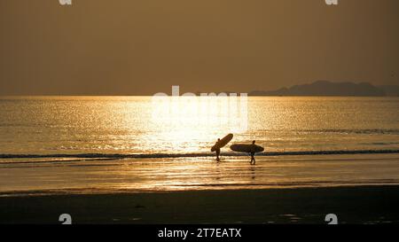 Silhouette von Surfer zwei Mann mit Surfbrett am Sonnenuntergang Strand, Gesundheit Lifestyle und Sport. Stockfoto