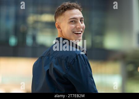 Positiv überrascht attraktiver junger kaukasier Student im ungezwungenen Blick zurück in die Stadt, zu Fuß, im Freien Stockfoto