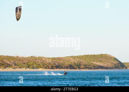 Ein Kitesurfer in Aktion beim Kitesurfen an der Mündung des Blackwood River in Hardy Inlet, Augusta, Südwest-Australien. Stockfoto