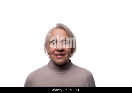 65 Jahre alte europäische reife Frau mit kurzen Haaren auf weißem Hintergrund Stockfoto