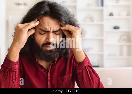 Nahaufnahme eines erschöpften indianers, der an Kopfschmerzen leidet Stockfoto