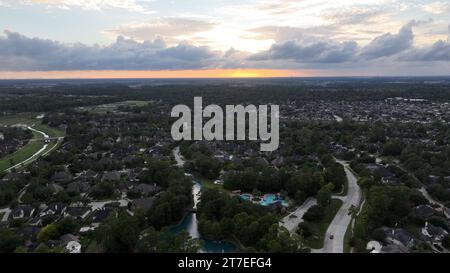 Dieses Luftbild zeigt ein ländliches Dorf mit einer kleinen Straße, die bei Sonnenuntergang durch das Dorf führt Stockfoto