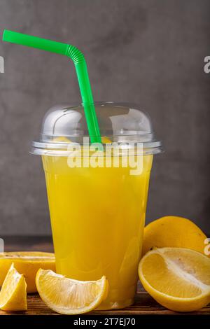 Eislimonade in Kunststoffglas auf Holztisch Stockfoto