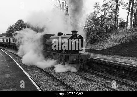 Stean-Zug verlässt jetzt den Bahnhof Llangollen See in Schwarzweiß, aufgenommen am 28. Oktober 2023. Stockfoto