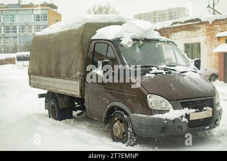 Gütertransport im Schnee. Russischer Lkw. Graues Gehäuse der Maschine. Industriegebiet im Winter. Stockfoto