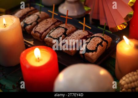 Nahaufnahme von hausgemachten Kuchen in Form von Gräbern, die mit Kreuzen mit Kerzen auf dem Tisch dekoriert sind Stockfoto