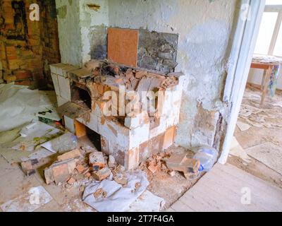 Verlassenes altes Landhaus - Inneres eines alten Landhauses mit Küche. Ein zusammengebrochener Landofen. Stockfoto