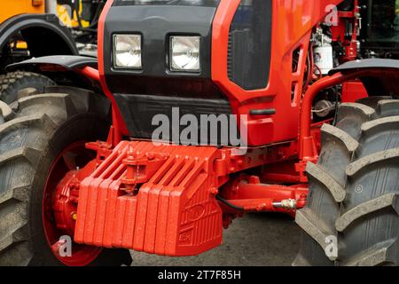 Nahaufnahme eines Teils des neuen roten Traktors. Fahrzeugbaugruppe. Stockfoto