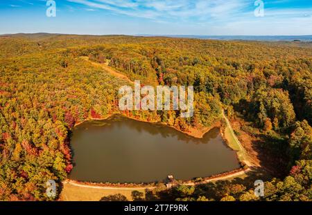Aus der Vogelperspektive der sich im Herbst verändernden Blätter um das ruhige Reservoir im Coopers Rock State Forest bei Morgantown, West Virginia Stockfoto