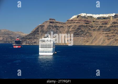 Virgin Voyages 'Resilient Lady' und MSC Cruises 'MSC Muscia' Luxus Kreuzfahrtschiffe unter den Klippen von Santorin, Kykladen Inseln, Ägäis, Griechenland. Stockfoto