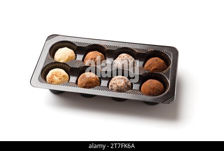 Set Schokoladentrüffel in Verpackung, isoliert auf weißem Hintergrund. Runde Trüffelbonbons aus schwarzer, Milch- und weißer Schokolade Stockfoto