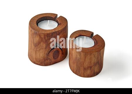 Zwei Kerzen in Holzleuchtern aus einem Baumstamm mit einem Riss auf weißem Hintergrund Stockfoto