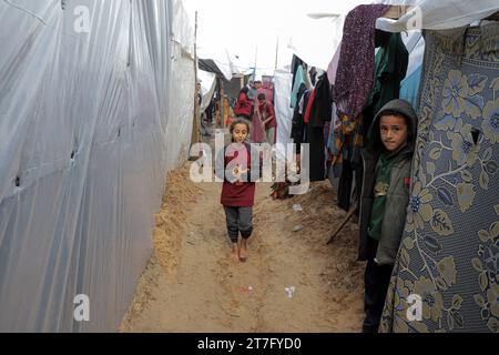 Gaza. November 2023. Vertriebene werden am 15. November 2023 in einem provisorischen Unterschlupf in Khan Younis im südlichen Gazastreifen gesehen. Nach Angaben des UN-Hilfswerks für Palästinaflüchtlinge im Nahen Osten (UNRWA) wurden seit dem 7. Oktober, als die Hamas einen Überraschungsangriff auf Südisrael verübte, fast 1,5 Millionen Menschen über den Gazastreifen vertrieben. Quelle: Rizek Abdeljawad/Xinhua/Alamy Live News Stockfoto