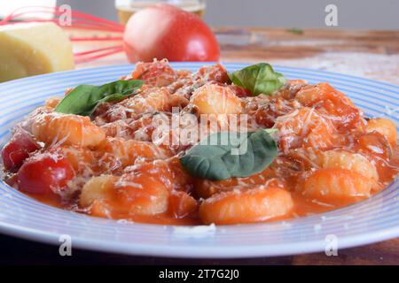 Pasta in roter Sauce mit Parmesankäse, Tomaten, Basilikum, Kräutern, köstliche Gerichte aus der italienischen und französischen Küche Stockfoto