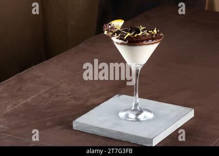 Schokoladenmousse und Käsekuchen mit Schokoladenüberzug und Biskuitbröseln. In Dessertschalen aus Glas. Auf dem weißen Hintergrund cremige Long Stockfoto