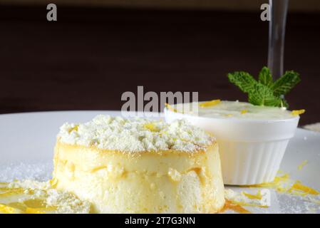 Köstliche Kondensmilch und Kokospudding auf einem weißen Teller - Kokospudding mit Eiern, die mit Pulvermilch bestreut sind Stockfoto