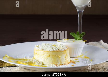 dulce de leche Pudding mit Zuckersirup und leckerer Sauerrahm in Pulver, serviert auf einem weißen Teller. Stockfoto