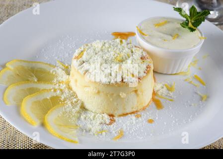 Köstlicher Dulce de leche Pudding mit Zuckersirup und leckerem Sahnepulver serviert auf einem weißen Teller. Stockfoto