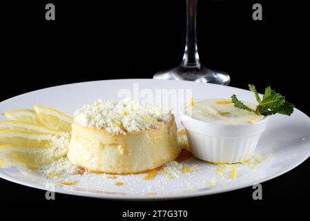 Köstliche Kondensmilch und Kokospudding auf einem weißen Teller - Kokospudding mit Eiern, die mit Pulvermilch bestreut sind Stockfoto