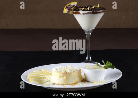 Kondensmilch und Eigelb Pudding mit köstlichem Sirup, der mit Frischkäse und hausgemachter Pulvermilch tropft. Kaffeekanne und kleine Töpfe mit Zucker, Bu Stockfoto