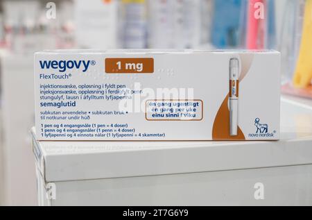 Verpackungsbox Wegovy (Semaglutid) injizierbares verschreibungspflichtiges Medikament, Gewichtsverlust-Medikament von Novo Nordisk AS. Regale im Apothekengeschäft im Hintergrund. Stockfoto