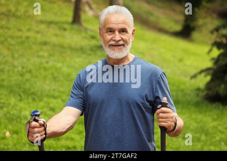 Senior Mann mit Nordic Walking Stangen draußen Stockfoto