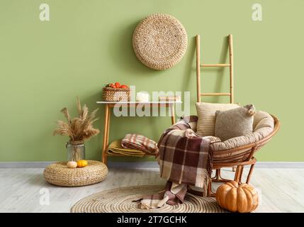 Stilvolles Wohnzimmer mit gemütlichem Sessel, Konsolentisch und Kürbissen Stockfoto