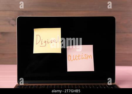 Haftnotizen mit dem Satz Digital Autism am Laptop auf dem Tisch, Nahaufnahme. Suchtverhalten Stockfoto