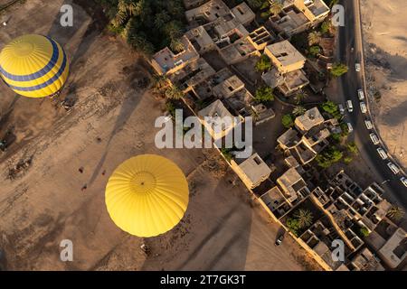 Von oben nach unten aus der Vogelperspektive sehen Sie Heißluftballons, die über die Kreuzung und Mauer zwischen der trockenen Wüste und den fruchtbaren nil-Tal-Farmen schwimmen Stockfoto