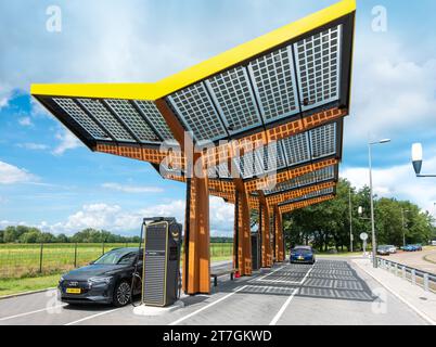 Ladestation für Elektrofahrzeuge an der Autobahn A2. Fastned Schnellladegerät. In die Dachkonstruktion integrierte Solarpaneele. Niederlande Stockfoto