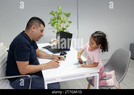 3-jährige brünette, lockige Lateinfrau zeichnet als Therapie für Autismus und ADHS mit Psychoanalytiker-Therapeutin Stockfoto