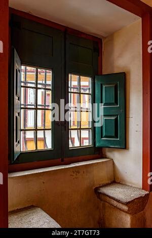 Altes Fenster in einer historischen Barockkirche mit Blick auf die Kolonialhäuser in der Stadt Ouro Pretro, Minas Gerais, Brasilien Stockfoto