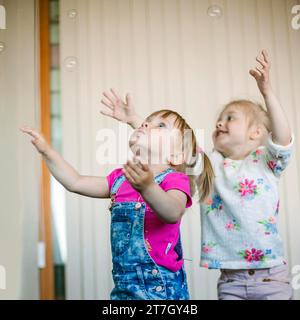 Kleine Mädchen fangen Seifenblasen-Raum Stockfoto