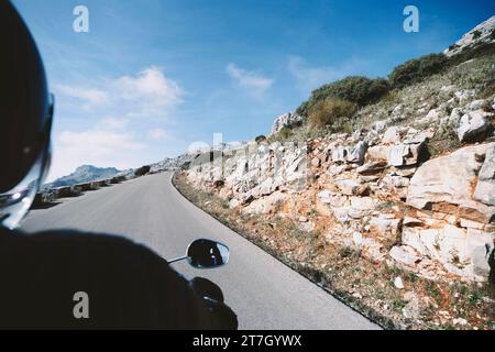 Person Motorrad in der Nähe eines Hügels Stockfoto