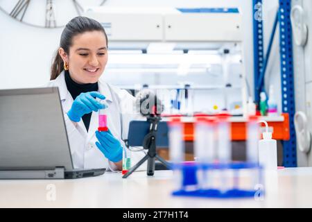 Junge Biologin, die ein Video mit Proben in einem Forschungslabor aufnimmt Stockfoto