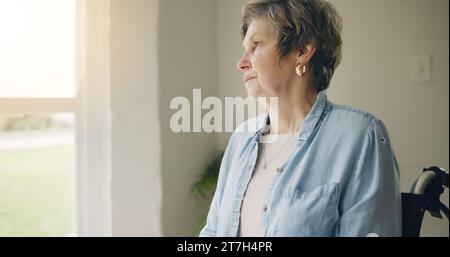 Rollstuhl, ältere Frau oder Denken an Gedächtnis durch Fenster im Pflegeheim oder Ruhestand mit Depression. Trauernostalgie, traurige Geschichte oder einsame Seniorin Stockfoto