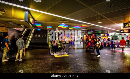 Passagiere, die an und aus den Automatic Fare Collection Gates an der Orchard MRT Station, Singapur, einsteigen. Stockfoto