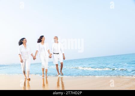 Glückliches älteres indisches Paar mit wunderschöner, junger Tochter, die den Urlaub am Strand genießt. Stockfoto